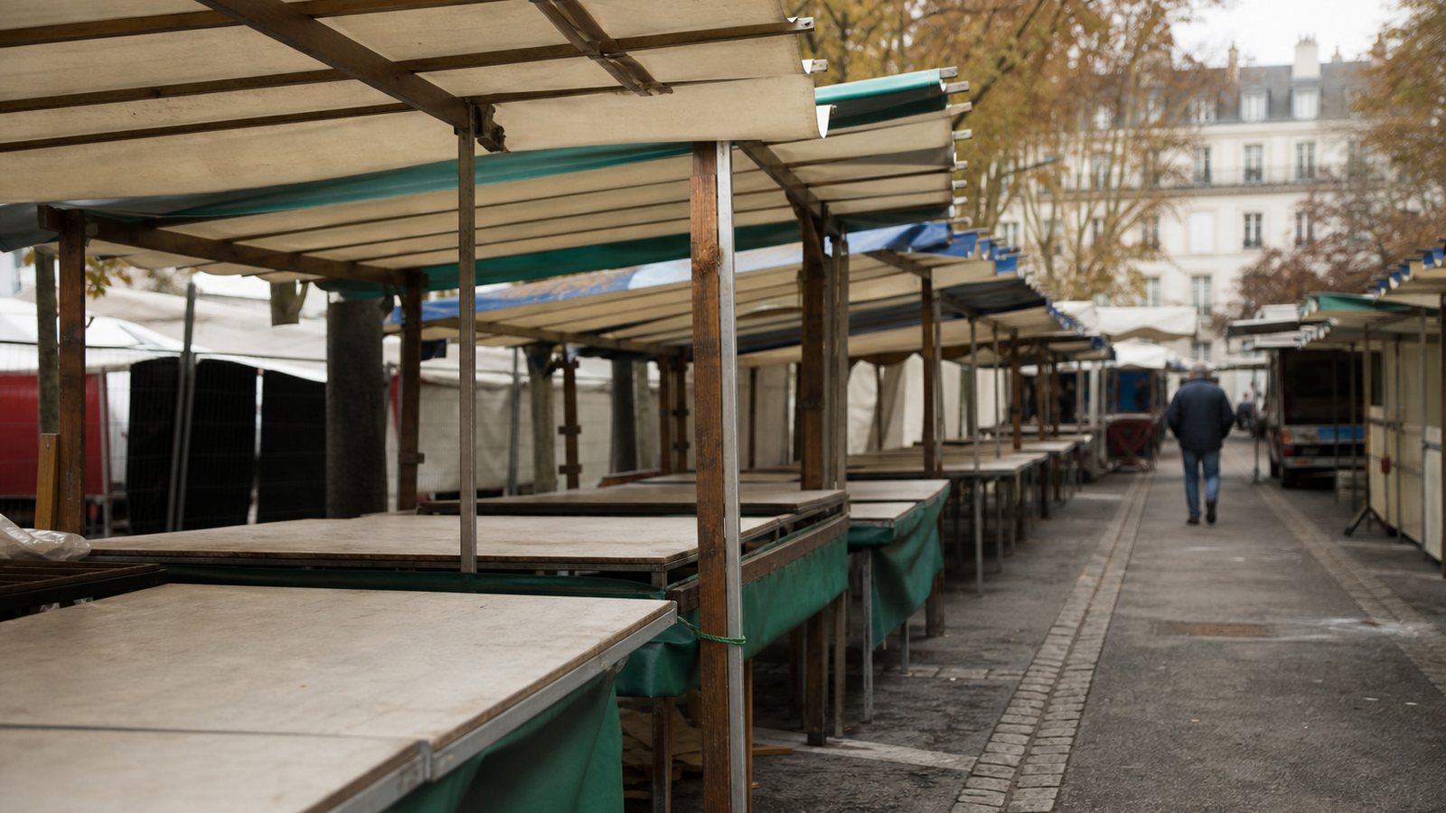 Organisateur au téléphone devant le plan d'un marché comportant des emplacements encore libres